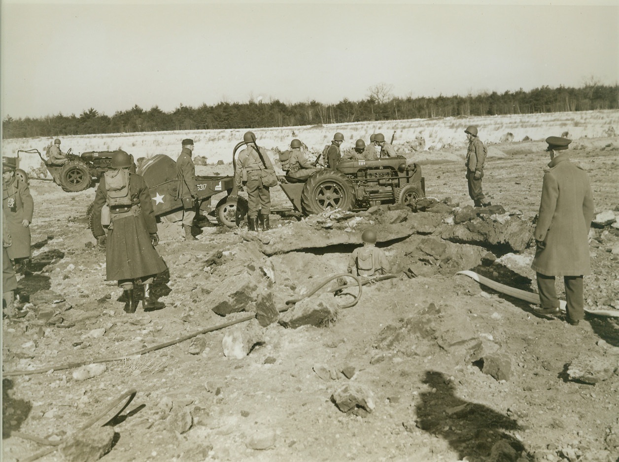 Getting to Work, 3/3/1943. Westover Field, Mass.—Their equipment unloaded from the planes that brought them to the site of a bomb explosion, airborne engineers, training at Westover Field, begin to repair the damaged earth runway. Credit: ACME.;