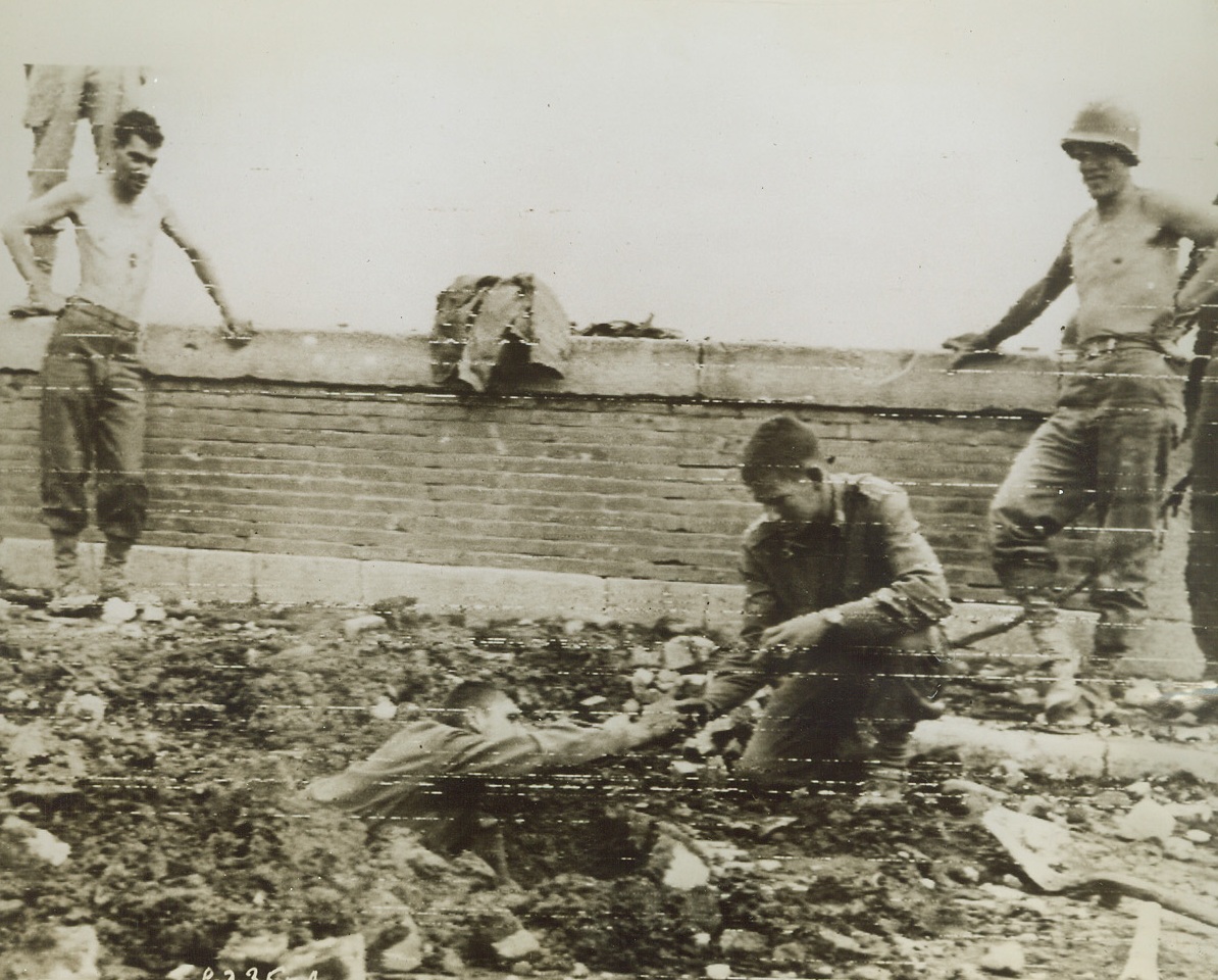Lucky Break, 10/13/1943. ITALY—Pvt. James J. Edwards, of Jamaica, L.I. passes an unexploded charge of TNT to Lt. Keith G. Gladfelter, of Mt. Vernon, Washington. The Nazis planted the explosive to blow up the bridge, but fled the Benevento area before they could finish the job. Both are members of the U.S. engineering division. Credit: U.S. ARMY SIGNAL CORPS RADIOTELEPHOTO FROM ACME.;