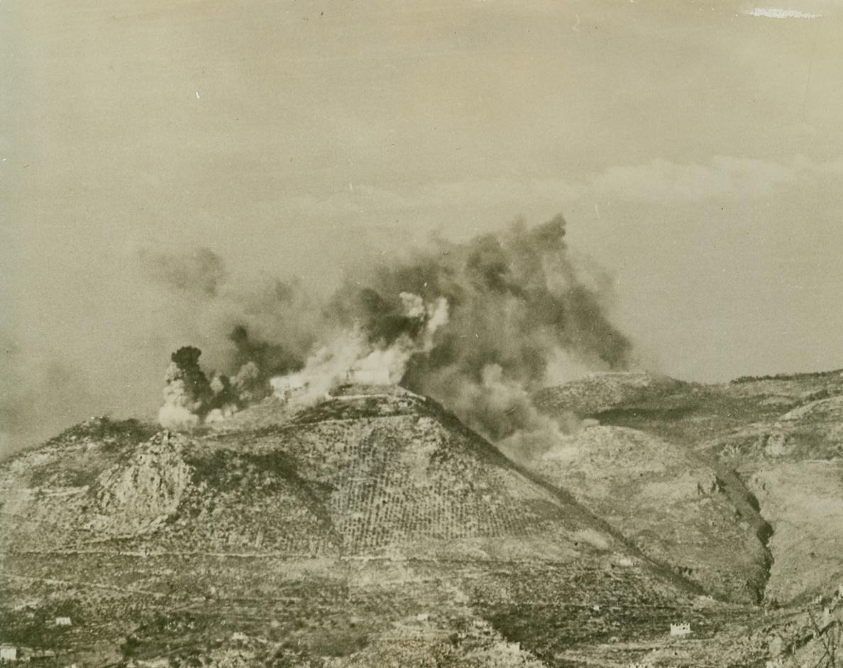 FORTIFIED MONASTERY BATTERED BY ALLIES, 2/25/1944. ITALY—The famous Benedictine monastery on the peak of Mount Cassino is turned into a smoke-shrouded inferno by Allied bombers. Explosives were followed by incendiaries, as some 250 medium and heavy bombers knocked out the religious building which the Nazis had turned into a fortress used to shell Allied troops. Credit: Acme;