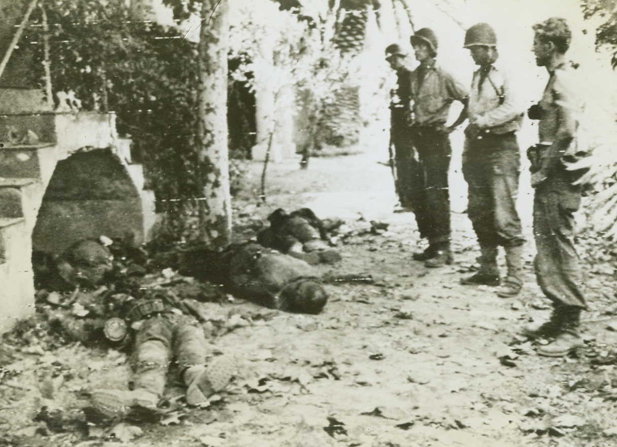Nazis Killed in New Invasion, 8/16/1944. France – U.S. soldiers (right) solemnly view the bodies of German soldiers killed in this Allied landing east of Toulon, in Southern France. Having secured their beachhead, Allies are driving inland proceeding according to plan. Credit: Army Radiotelephoto from ACME;