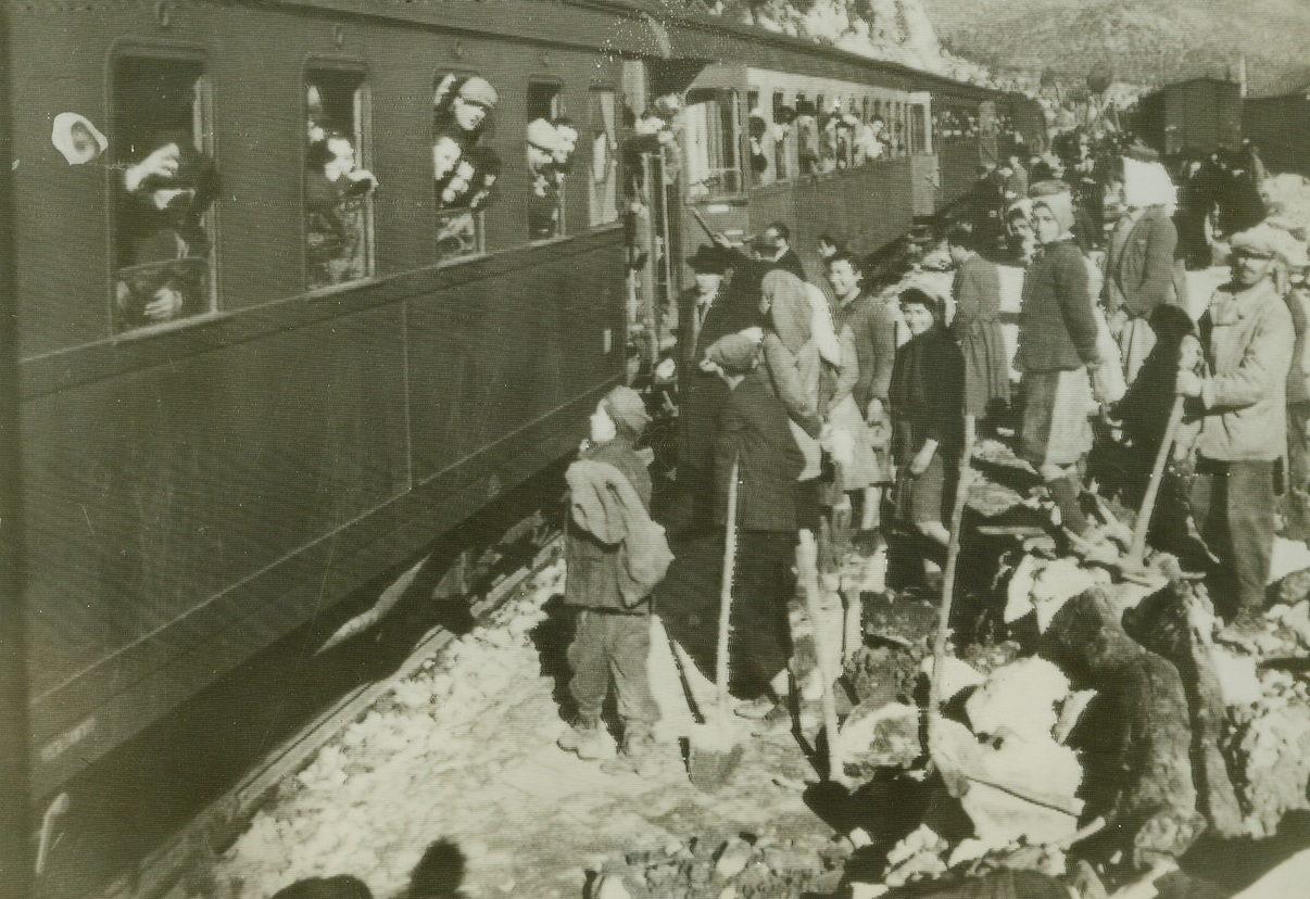 Democracy, Too, Makes Trains Run, 1/23/1945. Italy—Admiring Italians look on as the first civilian passenger train to operate between Rome and Naples since 1943, arrives at Formia Station. Credit: OWI radiophoto from ACME.;